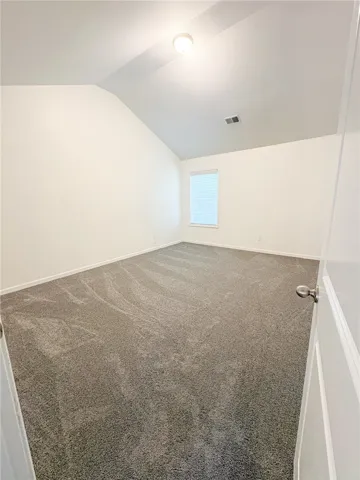 Bedroom 3 with vaulted ceilings and plush carpet, ready for your personal touch.