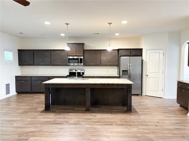 This kitchen features sleek countertops, modern appliances, and a spacious island.