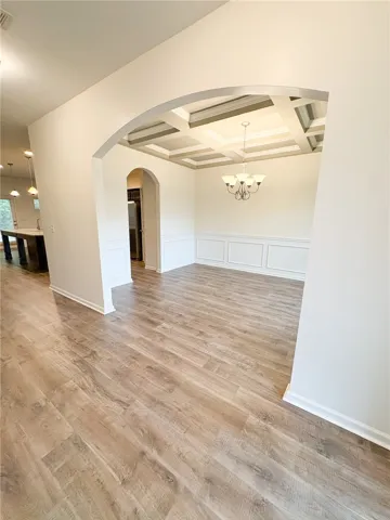 This inviting dining area features a unique coffered ceiling and elegant wood flooring.