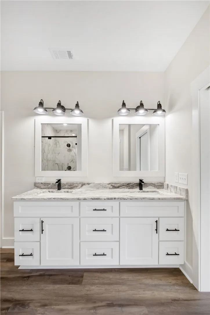 This modern bathroom features a double vanity with ample storage and sleek fixtures.