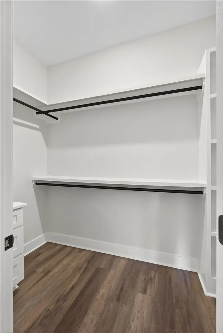 This spacious walk-in closet features ample shelving and hanging space for organized storage.