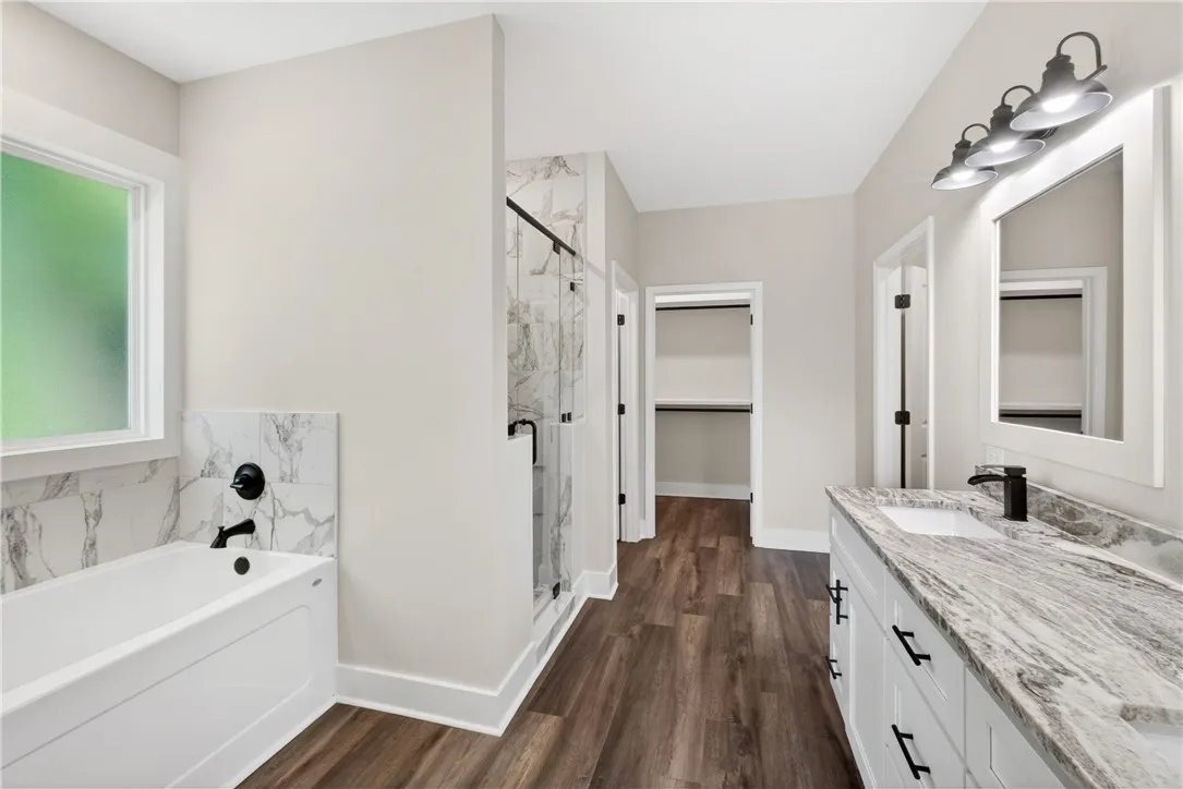 This spacious bathroom offers a relaxing soaking tub and elegant granite vanity.