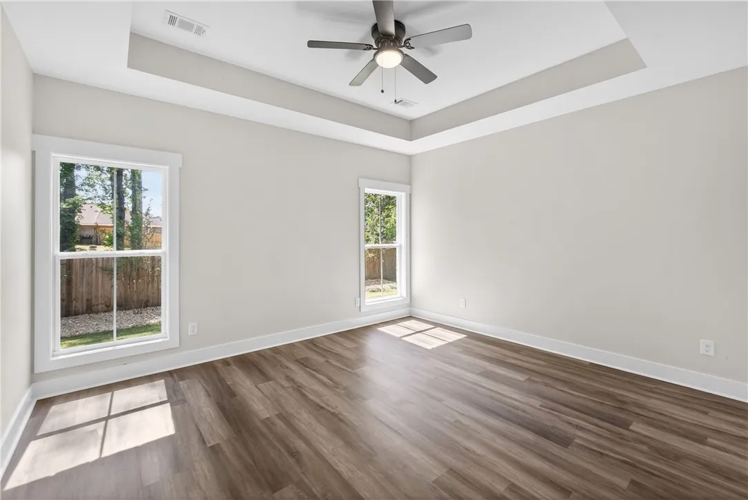 This airy room features ample natural light and elegant tray ceilings.