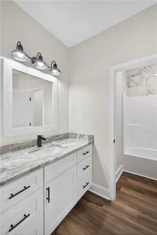 This bright bathroom features a modern vanity and a tiled shower, creating a fresh, clean space.