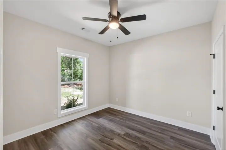 This serene bedroom offers ample light and comfortable flooring for peaceful living.