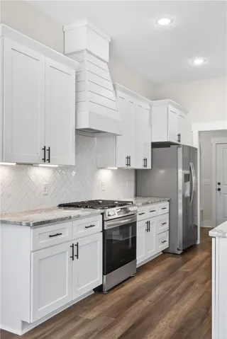 This modern kitchen features crisp white cabinetry, stainless steel appliances, and sleek countertops.
