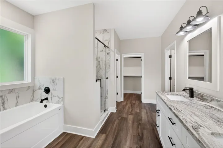 This spacious bathroom offers a relaxing soaking tub and elegant granite vanity.