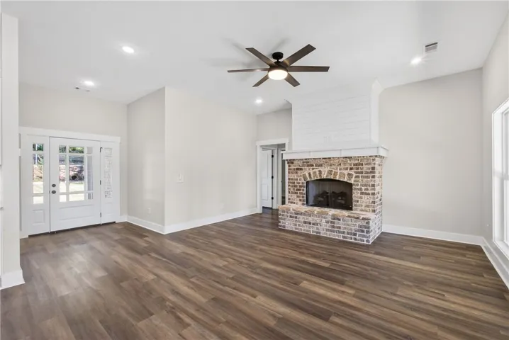 This living area features a brick fireplace and durable wood flooring.