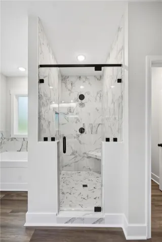 This modern bathroom features a spacious walk-in shower with elegant tile work and a convenient bench.