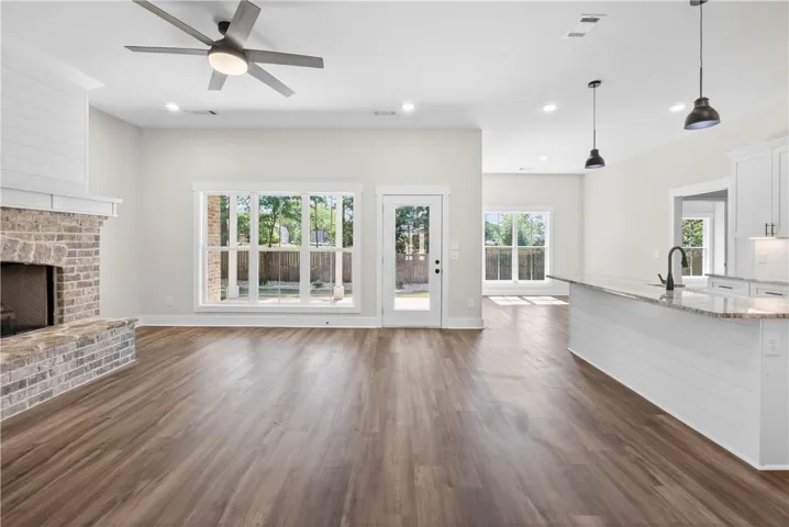 This airy open-concept space features warm flooring, a charming fireplace, and abundant natural light.