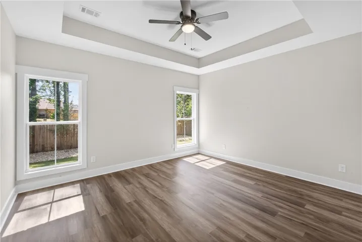 This airy room features ample natural light and elegant tray ceilings.