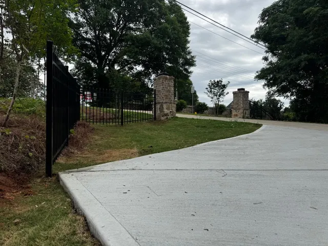 This property features a private entrance with a durable concrete driveway and sturdy fencing.