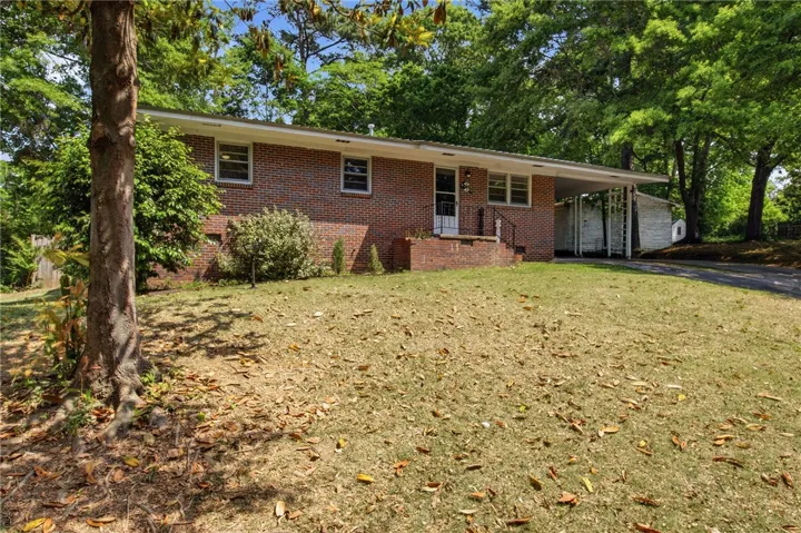 This classic brick residence features a welcoming entrance and mature trees, creating a serene environment.