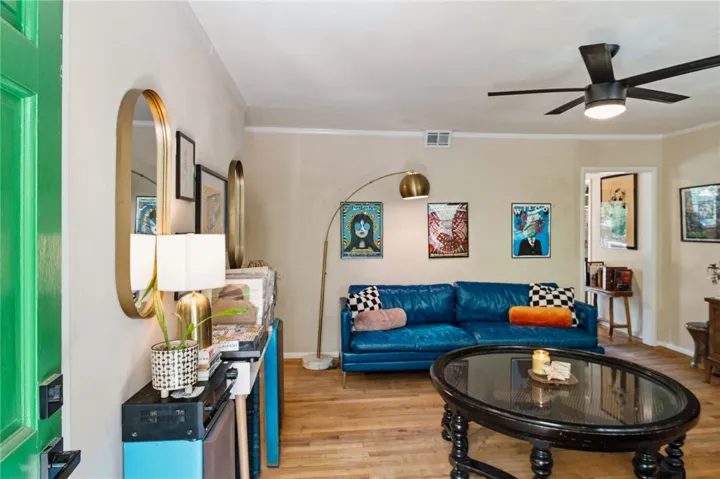 Bright and airy living area featuring a sleek ceiling fan and inviting hardwood floors.