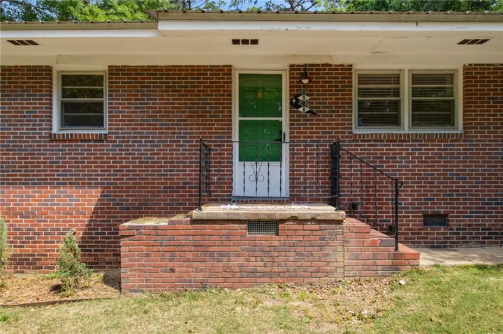 This classic brick residence features a welcoming entrance with a sturdy porch and wrought iron railings.