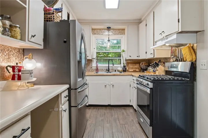 This galley kitchen features durable wood flooring and classic cabinetry.