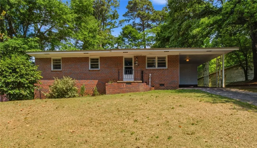 This classic brick residence features a spacious front yard and a convenient carport.