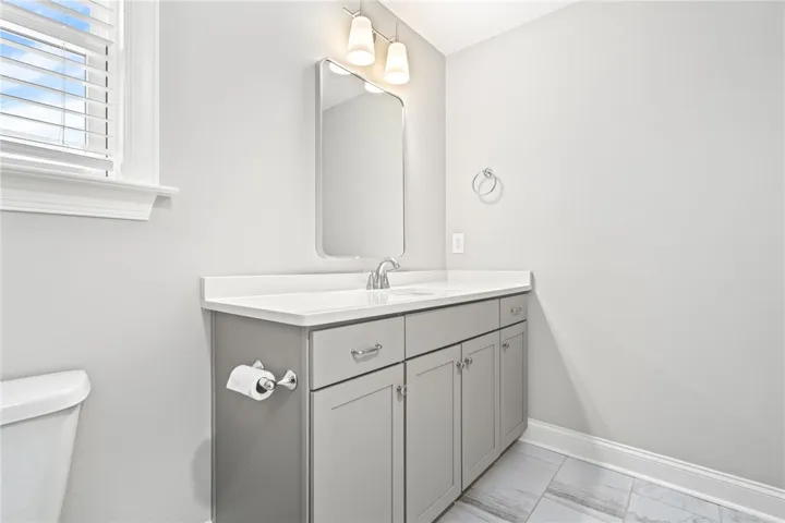 A well-appointed bathroom features a single vanity with ample storage and a contemporary mirror.