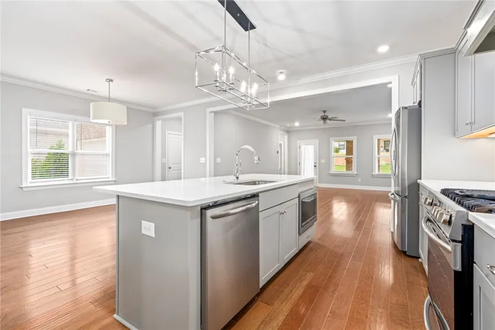An open concept kitchen with a center island and a full suite of stainless steel appliances.