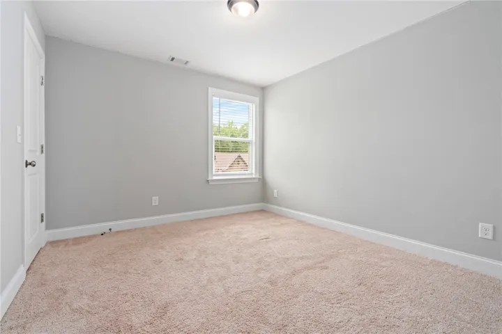 A well-lit room with plush carpeting, offering a peaceful retreat.