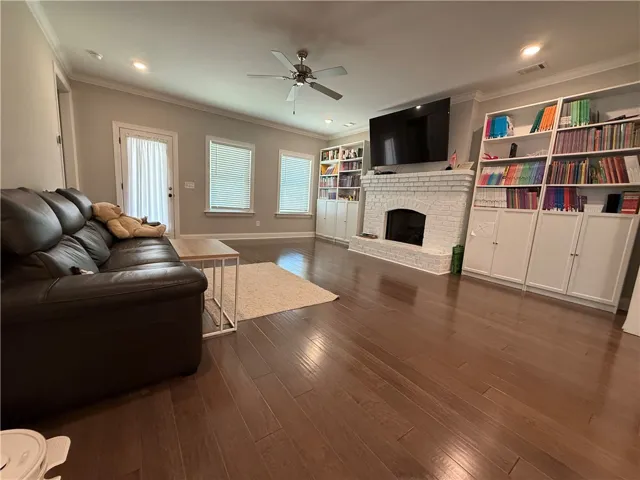 This inviting living space features gleaming hardwood floors and a cozy fireplace.