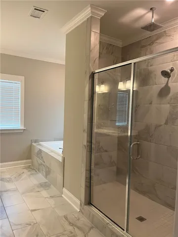 This spacious bathroom offers a relaxing soaking tub and a sleek, modern walk-in shower.