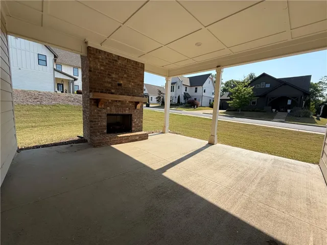 This inviting covered patio features a classic brick fireplace, perfect for outdoor gatherings.