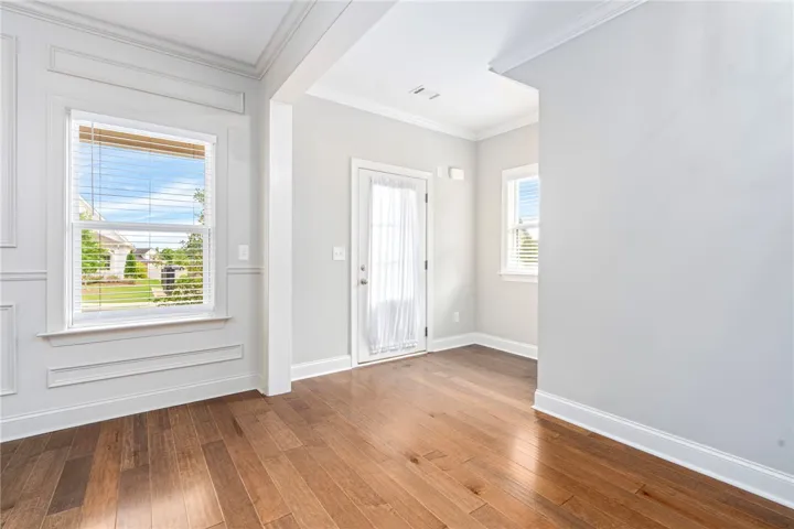 Rich hardwood flooring extends throughout this versatile living area, offering a clean, contemporary canvas.