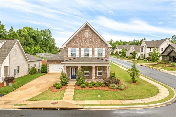 A classic brick exterior, complete with a covered porch and neatly landscaped front yard, welcomes you home.