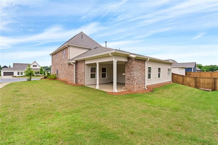 A well-maintained lawn surrounds this charming home with a brick and siding exterior and a comfortable covered patio.