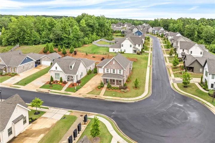 An aerial perspective reveals a winding street lined with neatly maintained homes, each boasting a well-manicured yard.