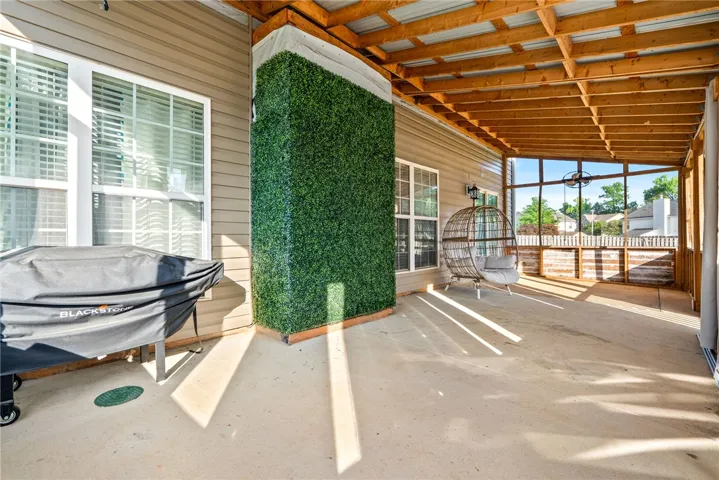 This inviting covered porch provides a serene outdoor living space for relaxation and entertainment.
