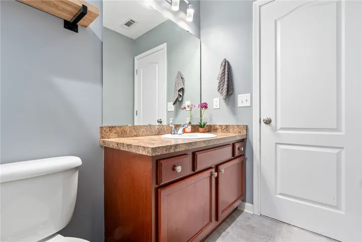 This bathroom features a sleek vanity and toilet, offering both style and functionality.