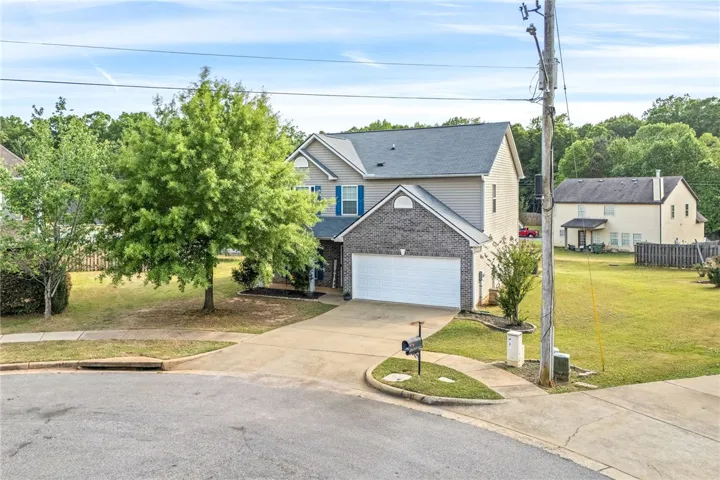 This charming residence features a well-maintained exterior and a welcoming curb appeal.