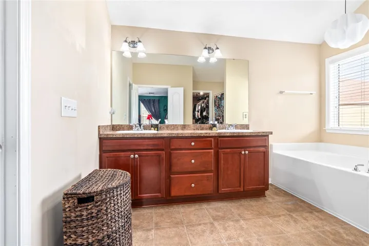 This spacious bathroom offers a double vanity and a comfortable soaking tub.