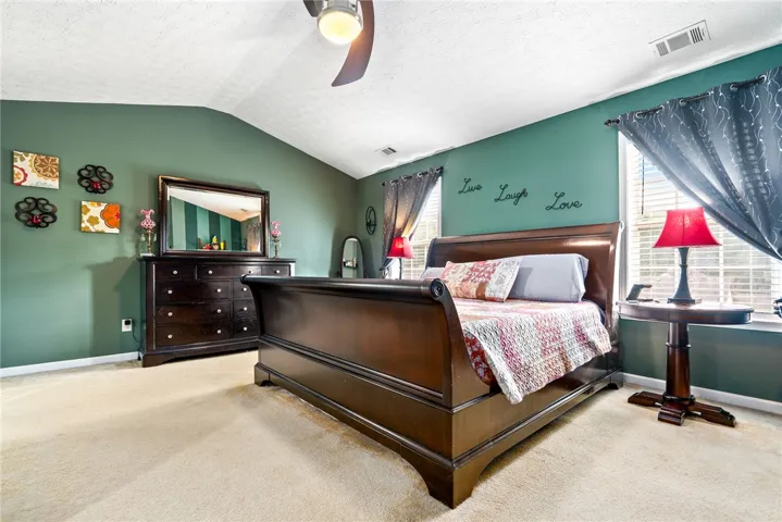 This spacious bedroom offers comfortable living with sloped ceilings and soft carpeting.