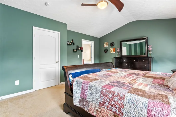 This cozy bedroom provides a comfortable retreat with a vaulted ceiling and soft carpet.