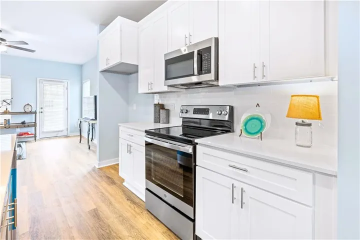 This modern kitchen features bright cabinetry, stainless steel appliances, and sleek countertops for easy meal preparation.