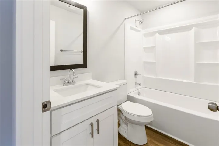This bathroom features a sleek vanity, modern fixtures, and a practical shower-tub combination.