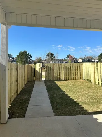 This private yard features a well-maintained fence and a clear path leading to the entrance.