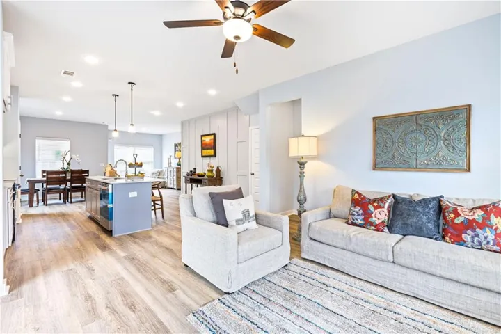 This bright, open-concept living space features stylish wood flooring and modern recessed lighting throughout.