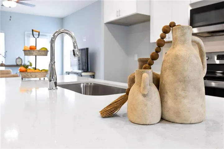 This modern kitchen features sleek countertops, a functional sink, and stainless steel appliances.