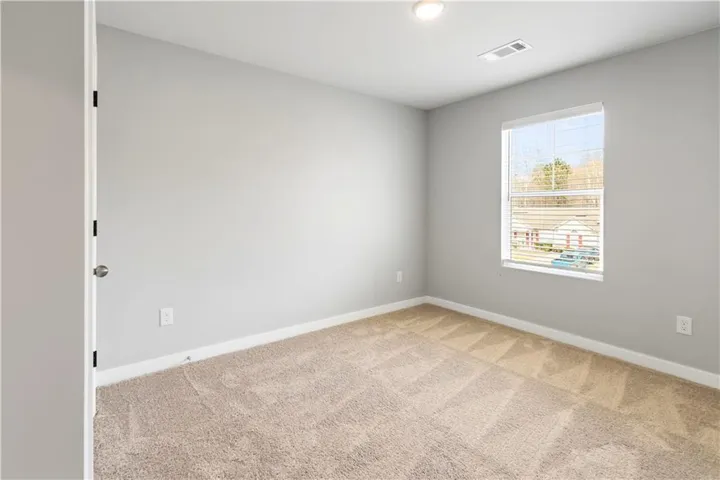 This versatile room offers a blank canvas for personalization, complete with soft carpeting.