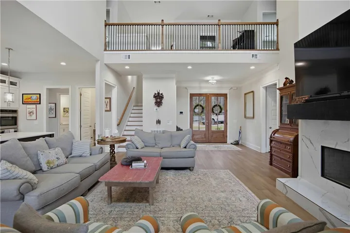 This grand living room features high ceilings and an elegant fireplace, perfect for gatherings.