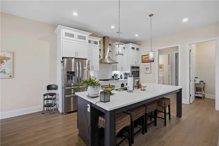 This spacious kitchen offers a large island with seating, stainless steel appliances, and ample cabinet space.