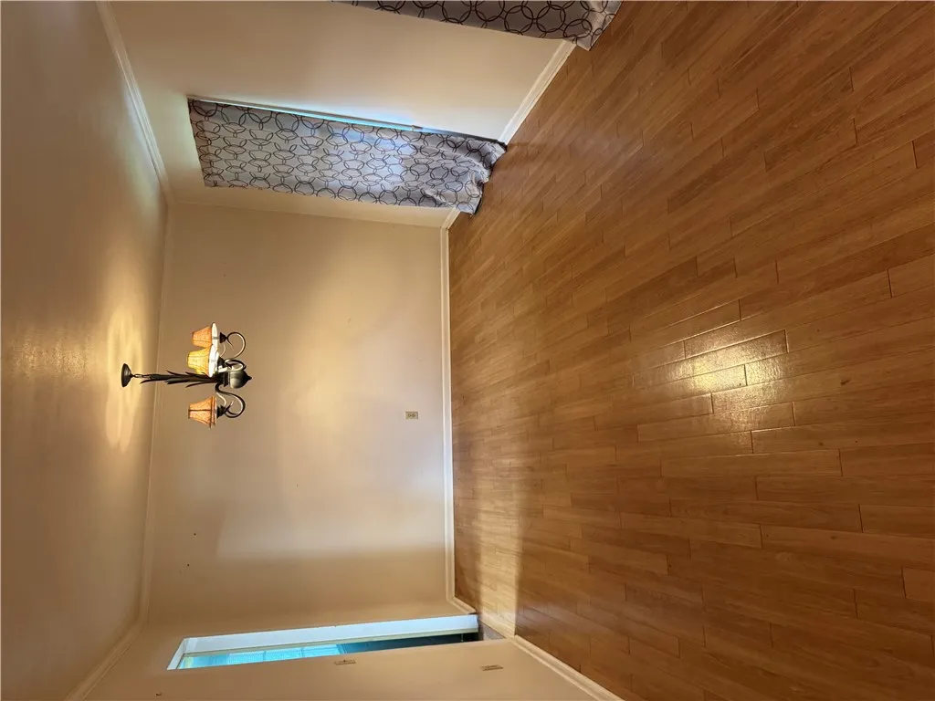 Hardwood flooring extends throughout this well-lit living area, perfect for gatherings.