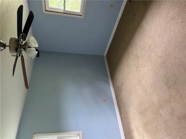 Relax in this tranquil room with carpeted flooring and an overhead ceiling fan.