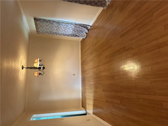 Hardwood flooring extends throughout this well-lit living area, perfect for gatherings.