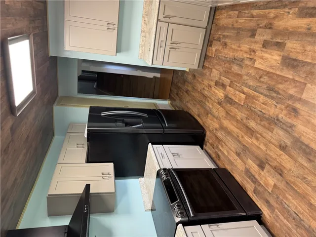 Well-equipped culinary space featuring sleek appliances and durable wood-look flooring.