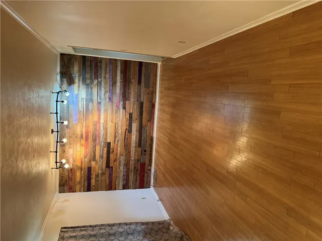 Rich hardwood flooring complements a distinctive accent wall with rustic charm.